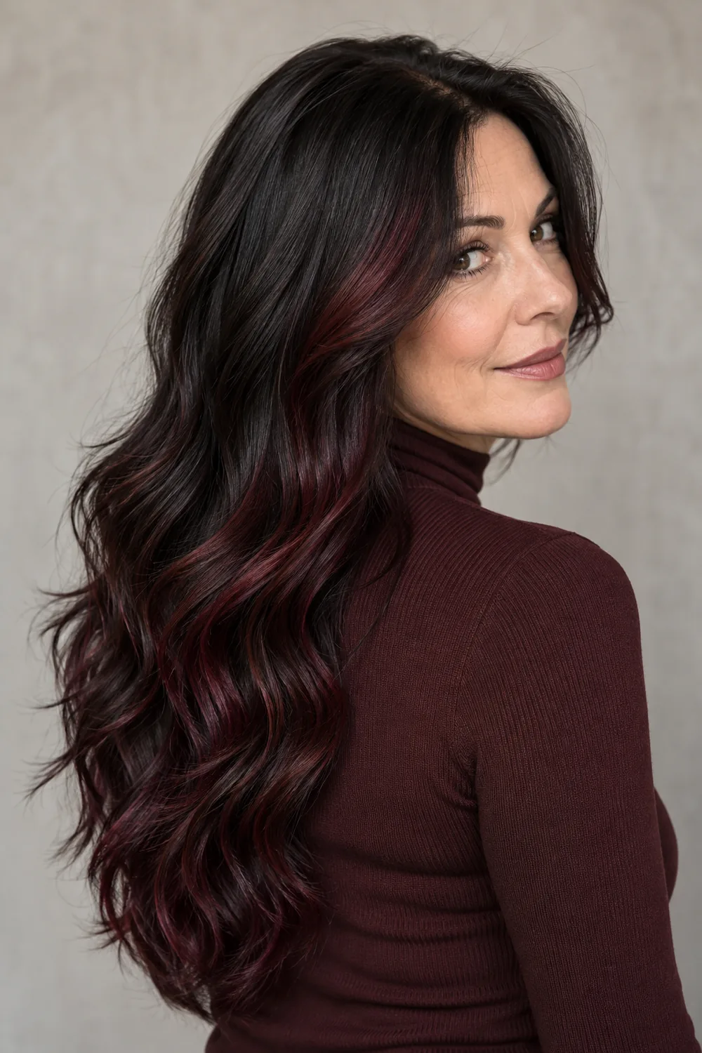 Long black waves with subtle deep plum-burgundy interior highlights, shown from a rear three-quarter angle.