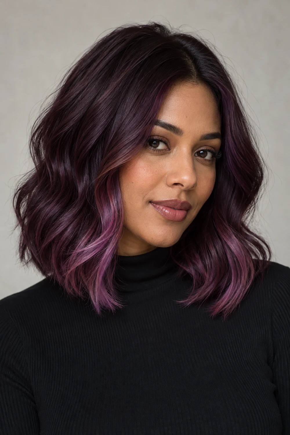 Adult woman with a dark plum wavy lob and rose-violet tips on the front face-framing layers.