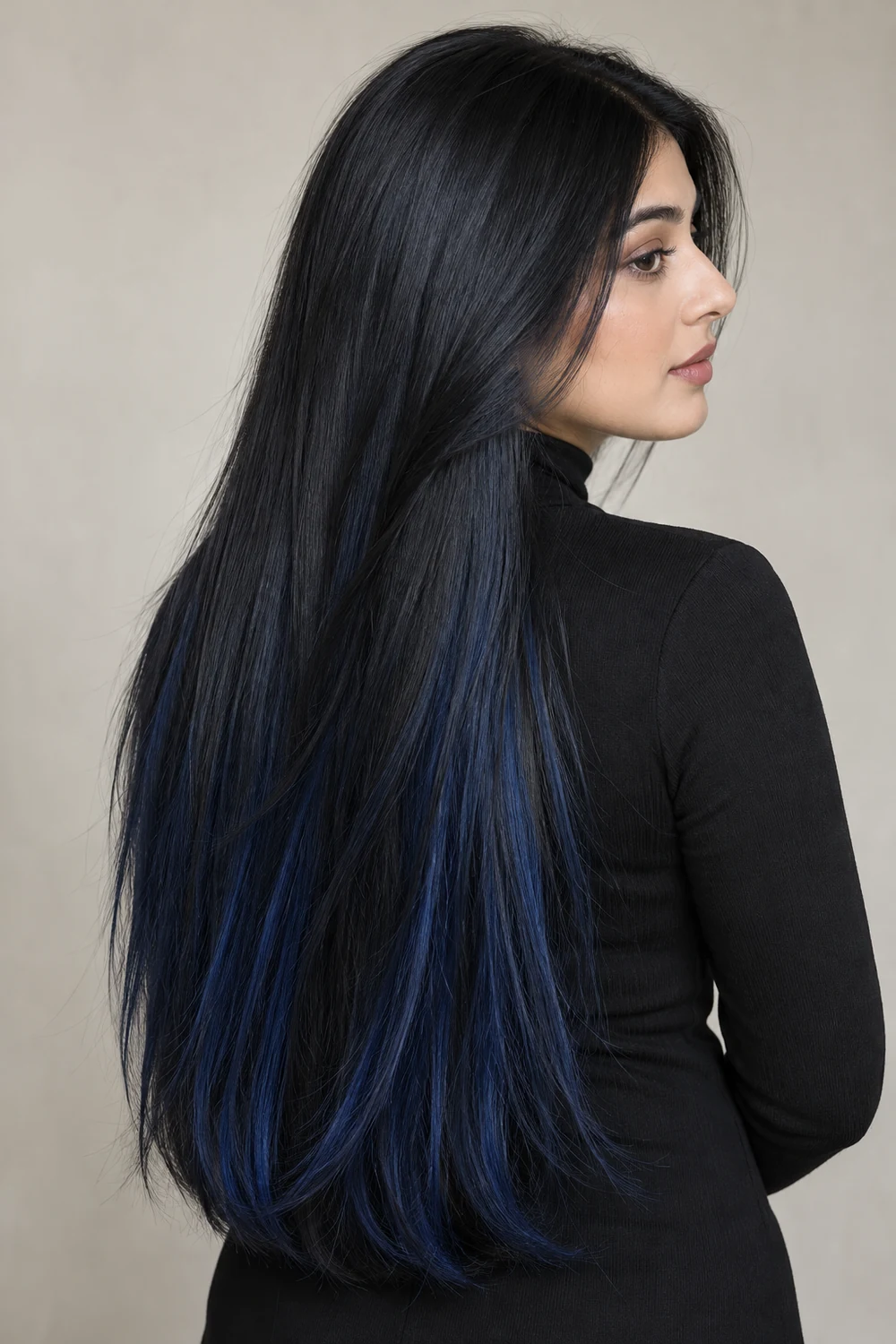 Sleek waist-length blue-black hair with discreet midnight-blue lower panels on a woman with a light cool complexion, shown in profile.