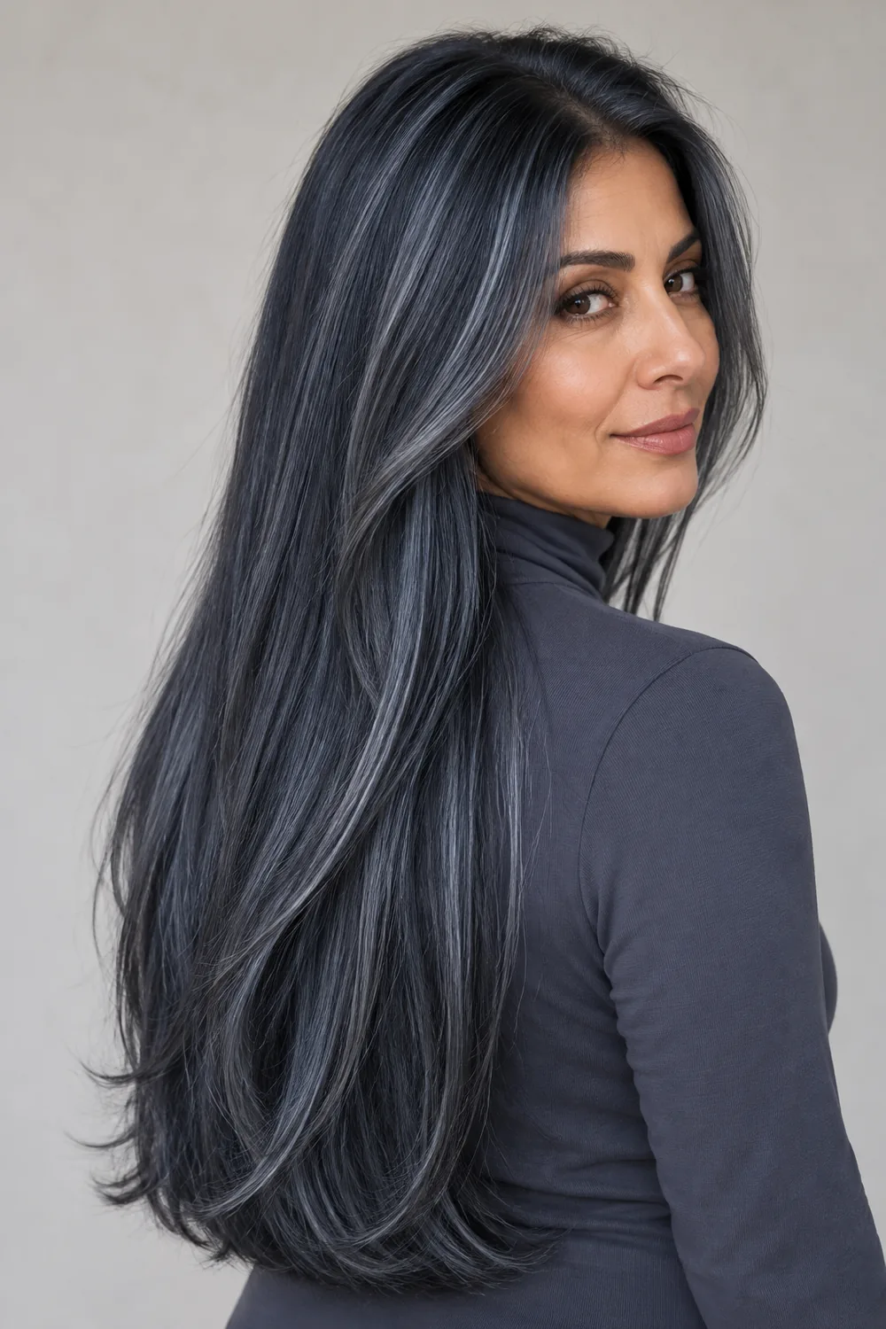Long, straight smoky navy hair with fine silver-blue highlights, worn by an adult woman in a slate high-neck top.